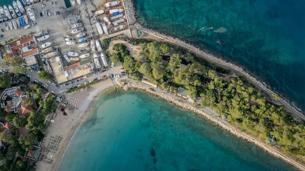 Moonlight Park Beach in Kemer with calm turquoise Mediterranean waters, sandy shore, and mountain backdrop