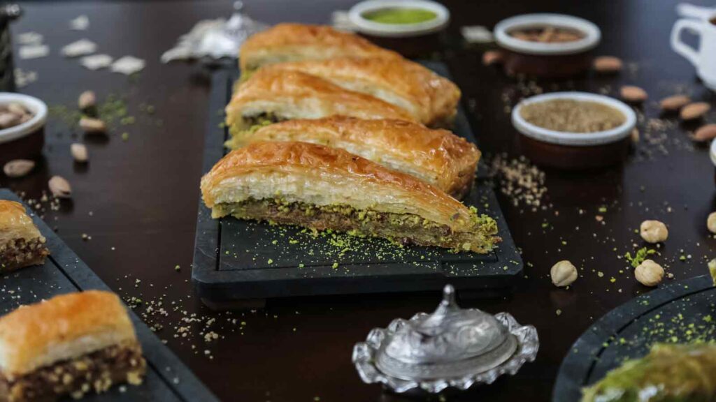 Traditional Antalya piyaz white bean salad and şiş köfte grilled meat skewers served on rustic Turkish table