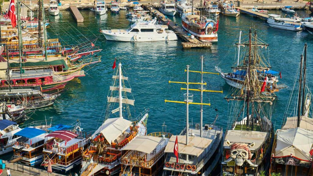 Narrow cobblestone alley in Kaleiçi Old Town lined with whitewashed Ottoman houses, hanging lamps, and colorful shops