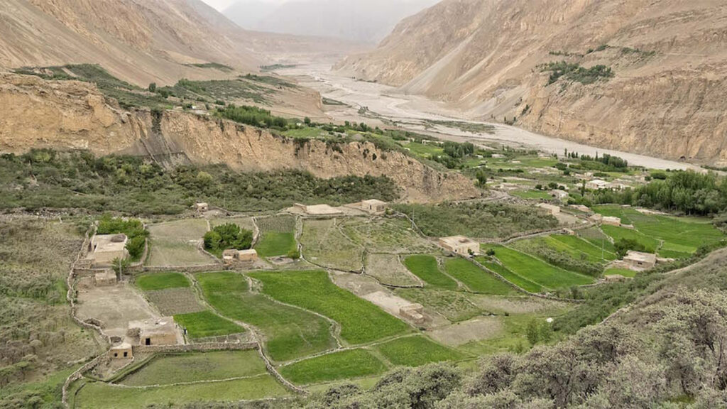 Remote Shimshal Valley showing traditional Wakhi village settlements surrounded by towering mountain peaks