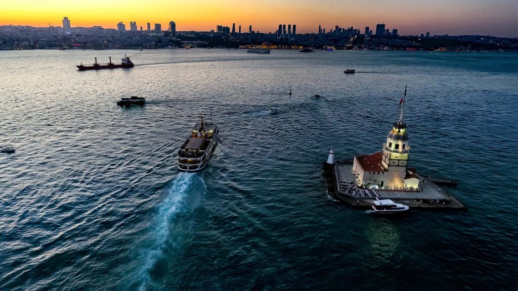 Bosphorus cruise boat at sunset with Istanbul skyline and historic mosques silhouetted